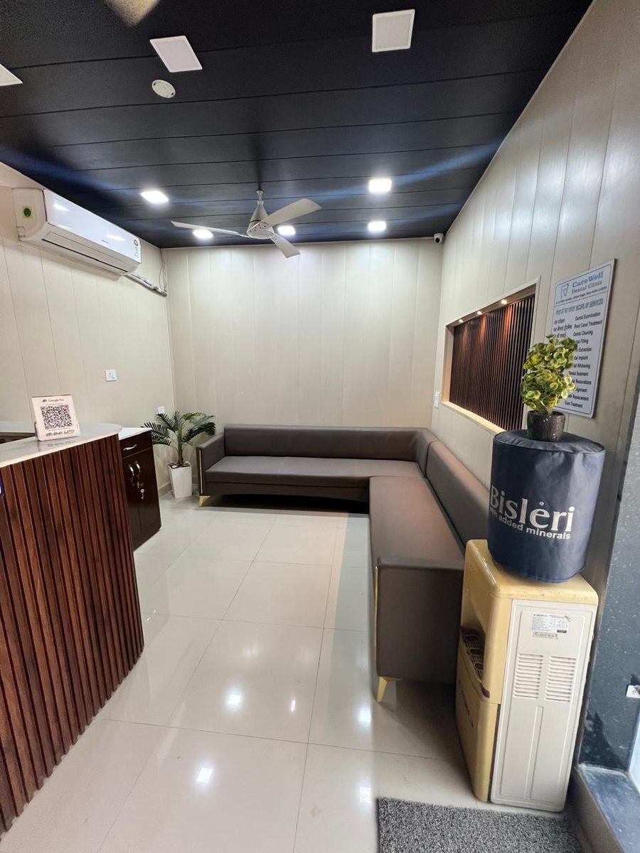 CareWell's air-conditioned waiting area, with bench seating, drinking water and the scope-of-services board