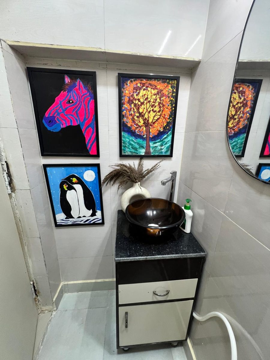 The clinic's washbasin area with hand wash and framed artwork